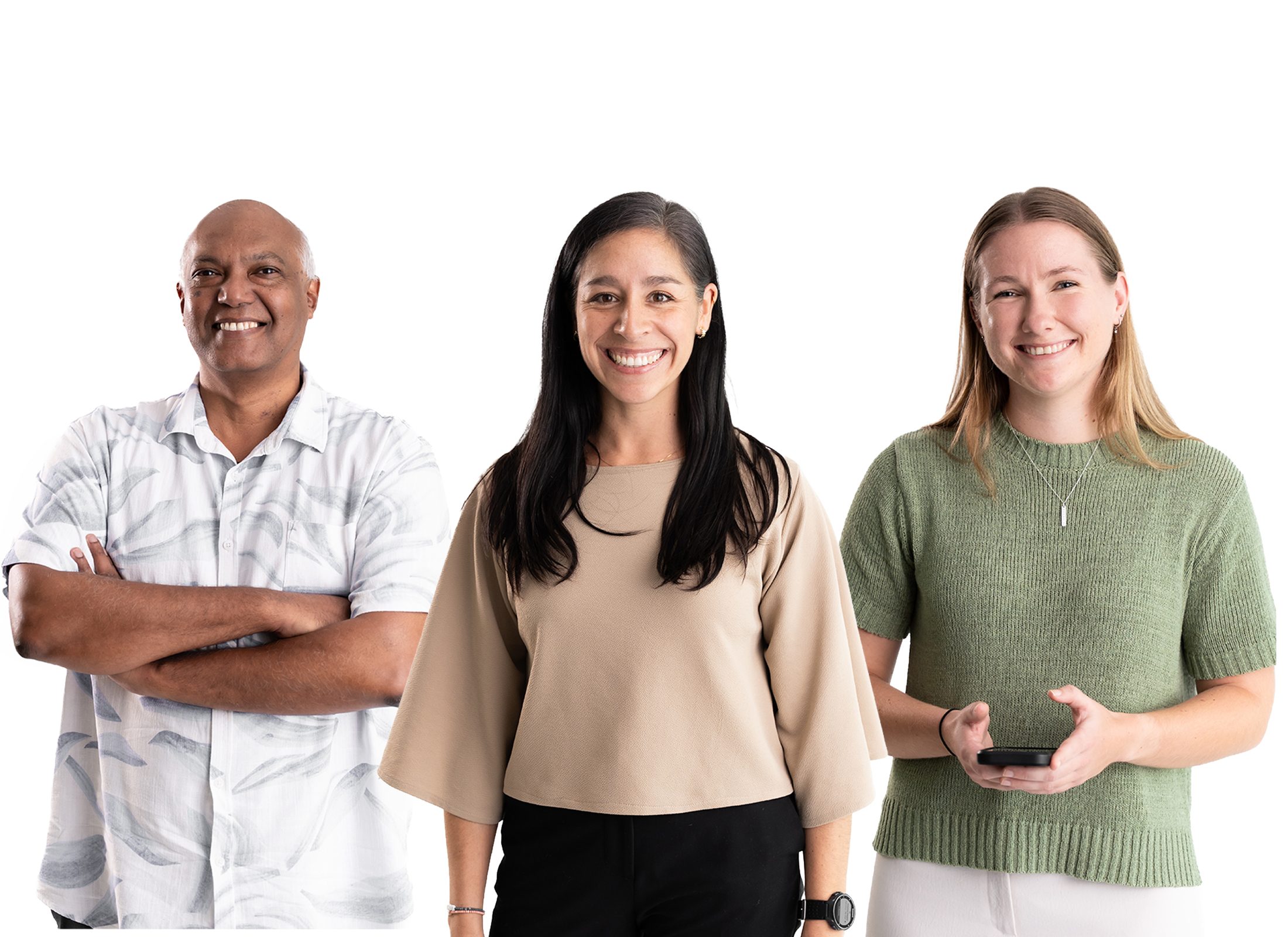 Three Kaikaranga team members wearing neutral colours are smiling happily at the camera. Farthest to the left is Angelo who is wearing a white shirt, in the middle is Manuela with long black hair wearing a brown top, and finally, Cara with blonde hair, green top holding a phone.